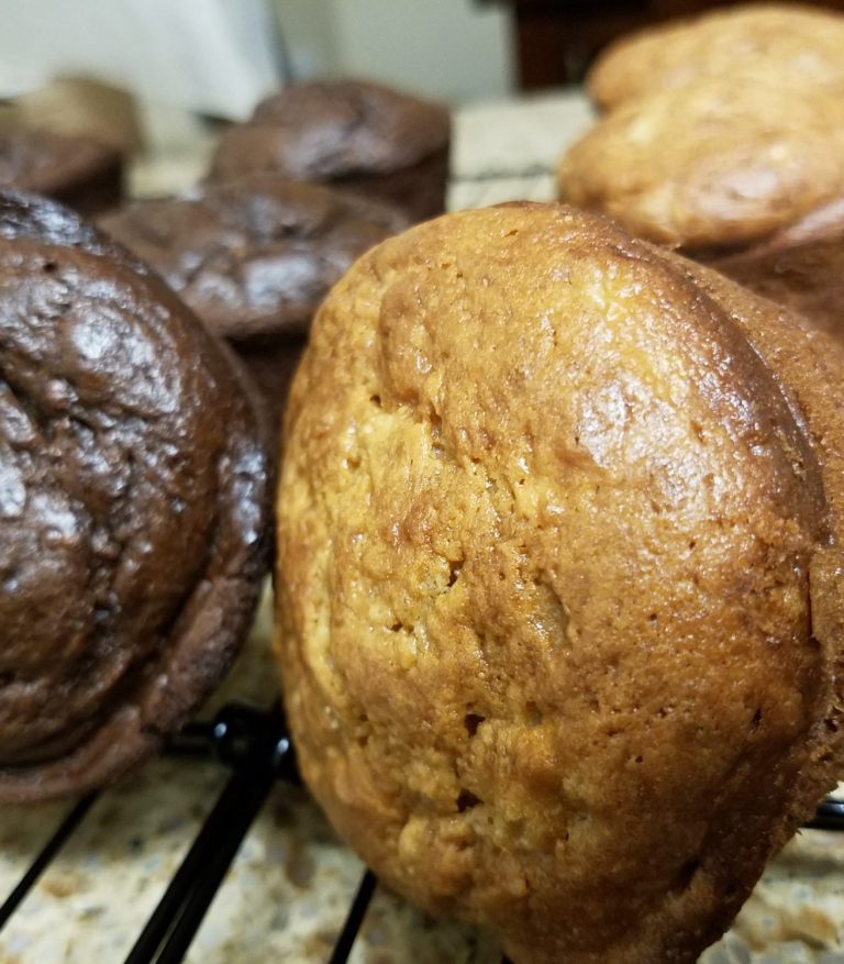 Brown and chocolate banana bread muffins cooling on a wire rack.